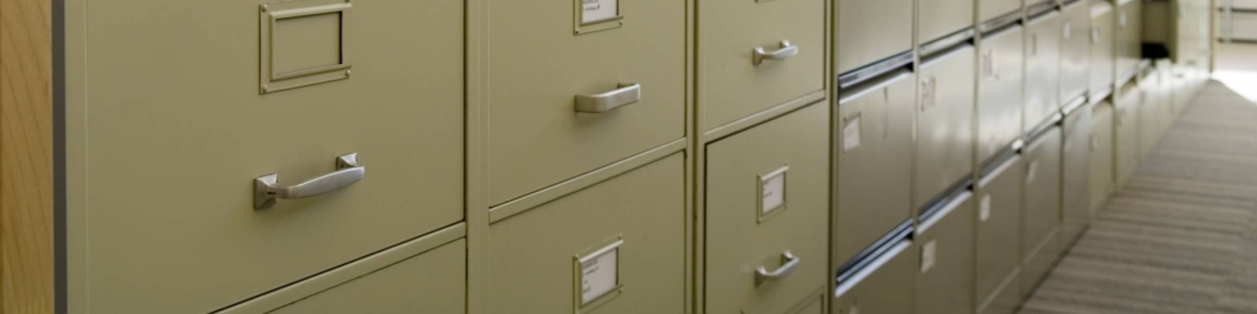 A man looking through a filing cabinet